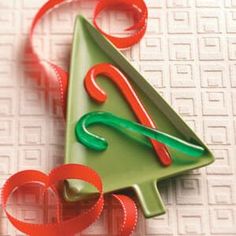 an ornament shaped like a christmas tree with red and green ribbons around it