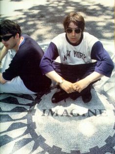 two young men sitting on the ground in front of a mosaic design with words that read new york