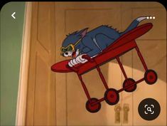 a cartoon cat riding on top of a red airplane