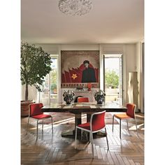 a dining room with red chairs and a painting on the wall