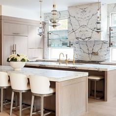 a kitchen with marble counter tops and white chairs