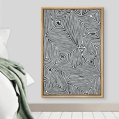 a bedroom with a white bed and a black and white abstract painting on the wall