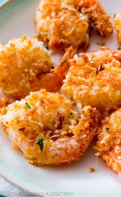 some fried food on a white plate with parmesan cheese and seasoning sprinkles