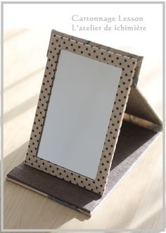 an empty photo frame sitting on top of a wooden table next to a pen and paper