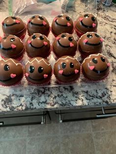 there are many cupcakes with chocolate frosting and hearts in the shape of faces