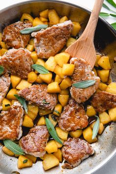 meat and pineapple in a skillet with a wooden spoon