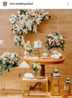 a table topped with cakes and flowers on top of a wooden floor next to a wall