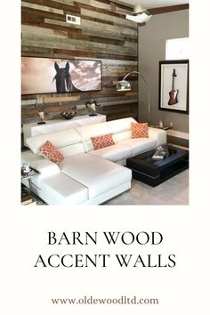 a living room with white furniture and wood accent walls on the wall, along with an orange throw pillow that reads barn wood accent walls