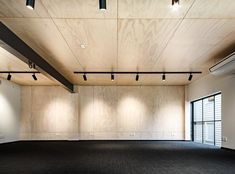 an empty room with wooden walls and black carpet