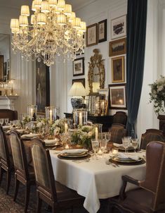 a dining room table is set with candles and place settings