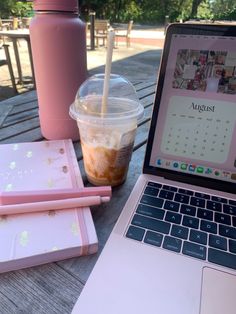 an open laptop computer sitting on top of a wooden table next to a cup of coffee