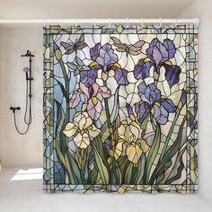 a shower curtain with purple and yellow flowers in the middle, against a white wall