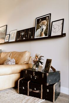 a living room filled with furniture and pictures on the wall