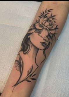 a woman's arm with a flower and leaves tattoo on the left side of her arm