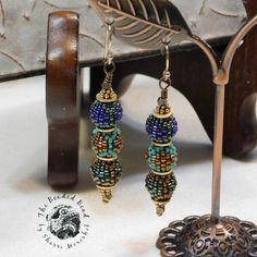 Three of my tiniest beaded beads make a sweet dangle earring. Peacock blues and greens are highlighted with rich gold and bronze metal. Earrings hand about 2 inches from the ear lobe on gold filled ear wires. Green Bollywood Peacock Design Earrings, Unique Blue Beaded Earrings With Round Beads, Unique Blue Beaded Earrings, Green Peacock Design Drop Earrings, Peacock Beads, Handmade Bohemian Peacock Earrings, Blue Hand-strung Round Beads Earrings, Unique Blue Beaded Nickel-free Earrings, Unique Blue Beaded Earrings Nickel-free