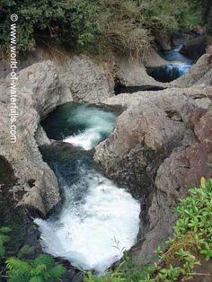 the water is running through the rocks in the river bed, and it looks like they are coming out of the cave