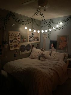 there is a bed with white sheets and pillows in the room that has many pictures on the wall