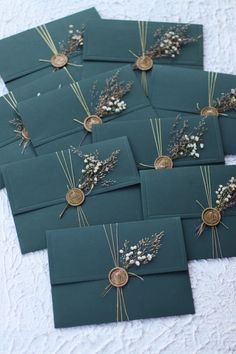 there are many cards that have flowers on them in the shape of envelopes with gold buttons