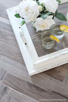 two glasses are sitting on a table with flowers