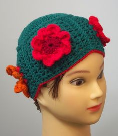 a mannequin head wearing a crocheted hat with flowers