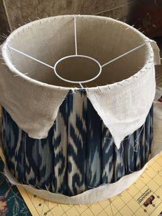 a blue and white lamp shade sitting on top of a table next to a ruler