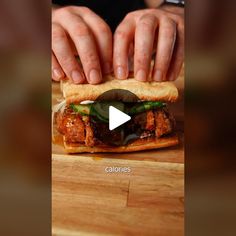 a sandwich with meat, lettuce and sauce on it is being held by someone