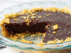 a chocolate pie with one slice cut out and the other half eaten in a glass pie dish