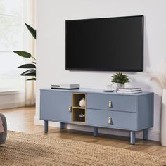 a flat screen tv mounted to the side of a blue cabinet in a living room