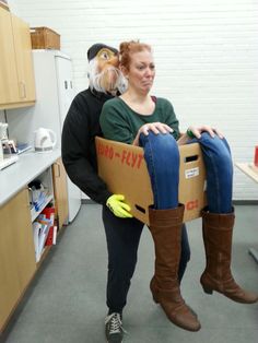 a man and woman are holding a cardboard box with bananas in it