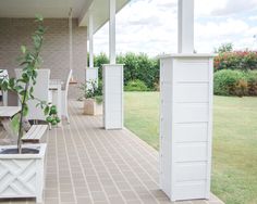 a porch with white furniture and plants on it