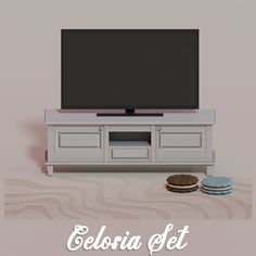 a flat screen tv sitting on top of a white entertainment center next to two cookies