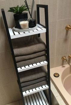 a bathroom with a sink, bathtub and towel rack in it's corner