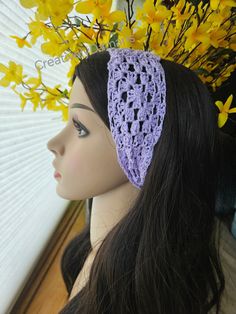 a crocheted headband with yellow flowers in the background and a mannequin's head