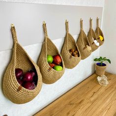 three bags hanging on the wall with fruits and vegetables in them