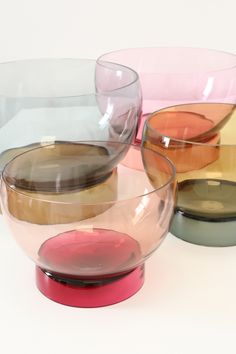 four bowls with different colors and shapes on the top one is pink, green, yellow, and brown