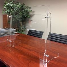 an empty conference table with clear acrylic stands on it's end bases