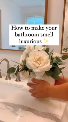 a person holding a bouquet of flowers in front of a bathroom sink with the words how to make your bathroom smell luxurious