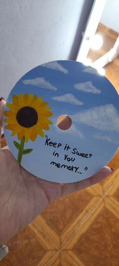 a person holding up a cd with a sunflower on the disc and words that read, keep it sweet in you memory