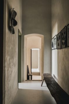 an empty hallway with benches and pictures on the wall