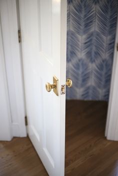 an open door in a room with blue wallpaper