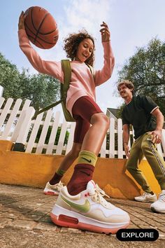 a man and woman are playing basketball outside