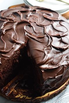 a chocolate cake on a plate with one slice cut out and ready to be eaten