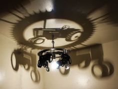 the shadow of a tractor is cast on the wall above a chandelier in a room