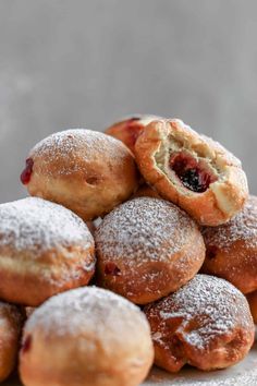 a pile of pastries sitting on top of a white plate covered in powdered sugar