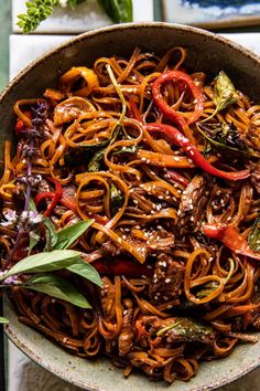 a bowl filled with noodles and vegetables on top of a table