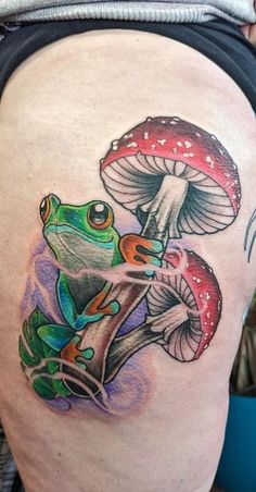 a woman's thigh with a frog and mushrooms tattoo on it