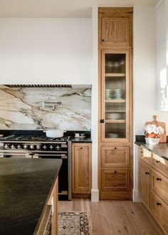 a kitchen with wooden cabinets and marble counter tops