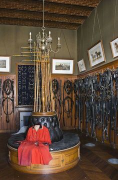 a room filled with lots of different types of horse tacks hanging on the wall