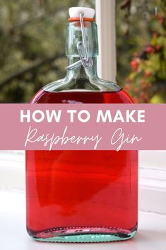 a bottle filled with raspberry syrup sitting on top of a window sill