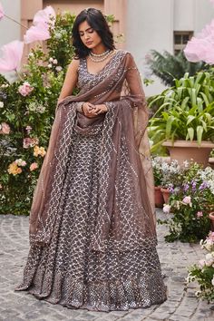 Greyish brown organza embroidered lehenga in mirror and thread work. Paired with embroidered choli and dupatta. Comes with can can.
Component: 4
Pattern: Hand embroidered
Type Of Work: Thread work, Mirror work
Neckline: Round
Sleeve Type: Sleeveless
Fabric: Organza
Color: Brown
Other Details: 
Scallop dupatta
12 Kali lehenga
Occasion: Wedding,Reception - Aza Fashions Sangeet Look, Kali Lehenga, Scallop Dupatta, Mirror Work Lehenga, Black Lehenga, Organza Lehenga, Lehenga Choli Wedding, Lehenga Designs Simple, Party Wear Lehenga Choli